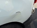 l'arrière d'un camion blanc dont le pare-chocs est cabossé