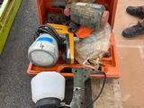 une boîte à outils posée par terre à côté d'une paire de chaussures
