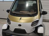 une petite voiture blanche et dorée garée dans un garage