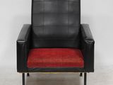 a black leather chair with a red cushion on a white floor