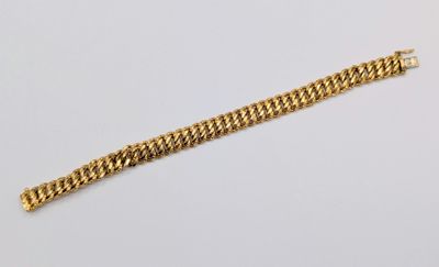 a close up of a gold chain bracelet on a white surface