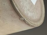 a close up of a vase with a tag on it