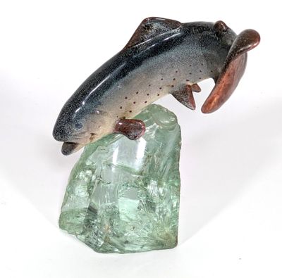 un poisson posé sur un rocher, sur un fond blanc