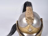 an old helmet with a long black hair on a white surface
