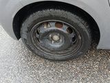 a car that has a flat tire on the side of the road