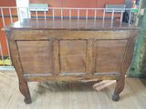 an old wooden cabinet with a metal rack on top of it