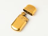 an image of a gold lighter sitting on top of a white surface
