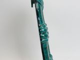 a close up of a green sculpture on a white surface