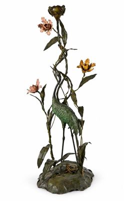 une statue représentant un oiseau et des fleurs posés sur un rocher