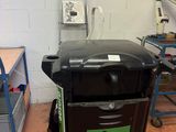 un chariot noir avec un autocollant vert dessus, dans une pièce