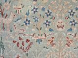 an antique persian rug with a floral design on a blue ground
