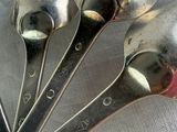 five spoons that are sitting on a table