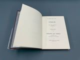 un livre ouvert posé sur une table, à côté d'une table bleue