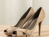 the shoes are on a wooden table with a curtain in the background