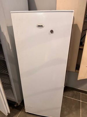 un réfrigérateur blanc dans le coin d'une cuisine
