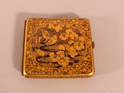 an image of a small gold box with a bird and flowers on it