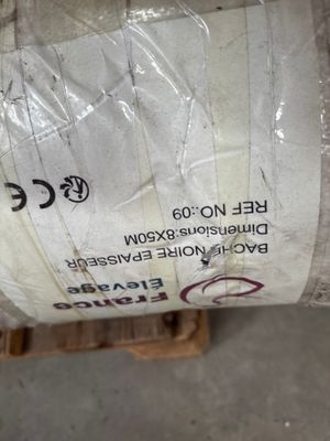 un gros rouleau de papier blanc posé sur une palette dans un entrepôt