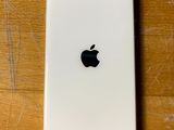 un gros plan d'un iPhone blanc posé sur une table en bois
