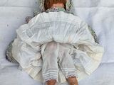 a doll that is laying down on a white sheet