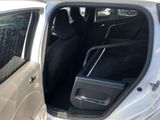a car with the door open and a suitcase in the back seat