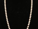 un collier de perles blanches sur un mannequin noir