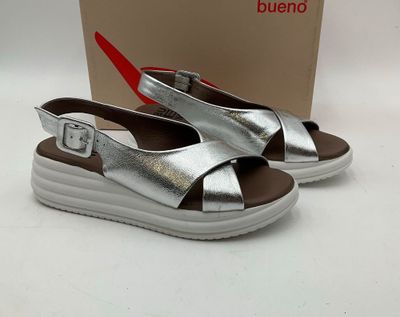 sandales en cuir argenté avec des boucles et un boîtier sur un fond blanc