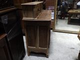 une armoire en bois au milieu d'une pièce, avec un grand miroir