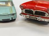 two toy cars sitting next to each other on a white surface