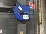 a blue hose attached to the wall of a garage