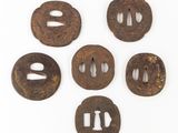 six tsubas de fer ornées de motifs sur un fond blanc