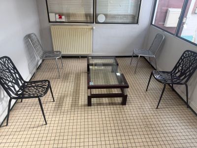 des chaises et une table dans une pièce dotée d'une fenêtre et d'un radiateur