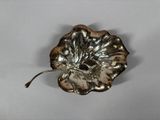 an image of a silver plate with a leaf on it