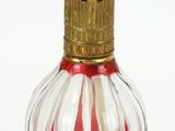 un vase en verre rouge et blanc surmonté d'une couronne dorée