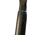 a large knife that is sitting on top of a piece of metal