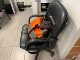 a black chair with an orange bag on top of it