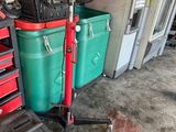 a red scooter sitting next to a stack of green and red bins