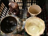 a basket filled with different types of vases and bowls