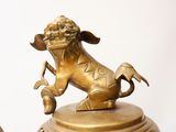 a gold statue of a dog and a cat on a pedestal