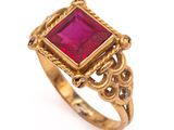 gros plan d'une bague en or avec une pierre rose