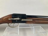 a close up of a rifle on display on a clear stand