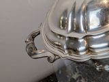 a silver platter with a lid on a marble table