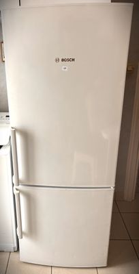 a white refrigerator sitting in a kitchen next to a stove