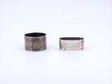 two silver rings sitting next to each other on a white surface