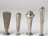 three silver vases and a salt shaker on a white surface