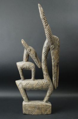 a sculpture of a bird and a bird sitting on top of a chair