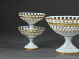three white and gold glass bowls with gold rims on them