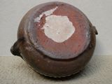 un pot marron avec une tache blanche dessus