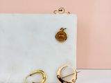 a close up of a pair of earrings on a marble surface