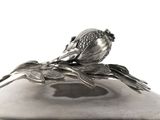 a silver plate with a bird on top of it