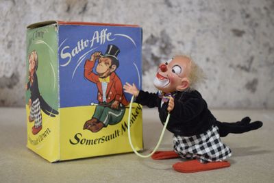 un clown en peluche tenant un tuyau d'arrosage devant une boîte